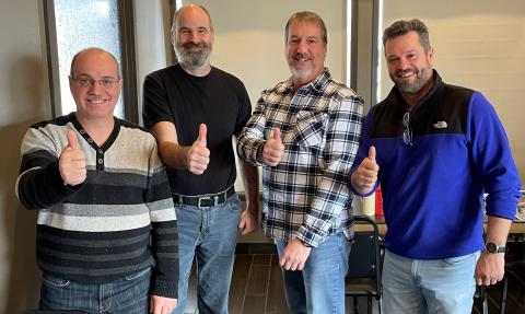 4 employés de chez convermat souriant avec leur pouce en l'air