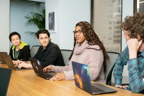 4 personnes qui travail en équipe à l'ordinateur